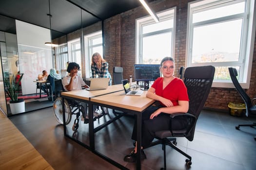 A diverse group of business professionals collaborates in a modern startup coworking center, utilizing a mix of paper-based and technological tools such as mobile phones and computers .