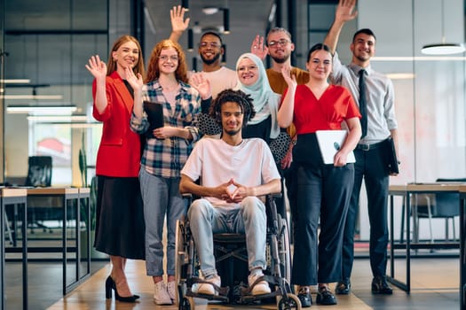A diverse group of young business people walking a corridor in the glass-enclosed office of a modern startup, including a person in a wheelchair and a woman wearing a hijab.
