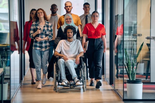 A diverse group of young business people congregates within a modern startup's glass-enclosed office, featuring inclusivity with a person in a wheelchair, an African American young man, and a hijab muslim woman