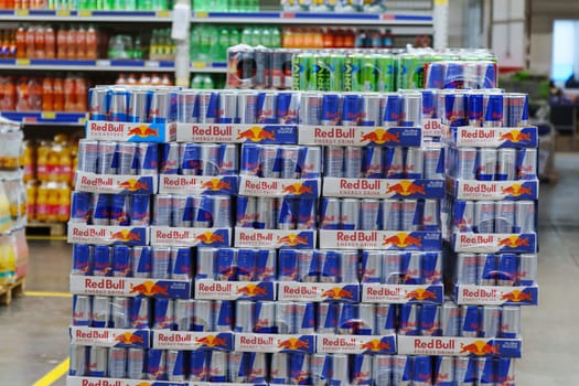 Tyumen, Russia-March 02, 2024: Display in a store is overflowing with cans of Red Bull energy drink, neatly stacked and organized to attract customers.