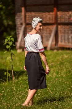 a woman in Ukrainian national costume walks on the lawn