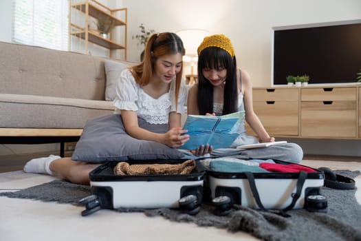 Friendship. Travel together. Two asian young woman friends packing for summer vocation. preparation planning concept.