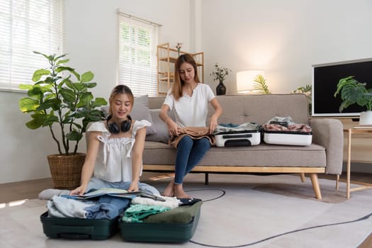 Friendship. Travel together. Two asian young woman friends packing for summer vocation. preparation planning concept.