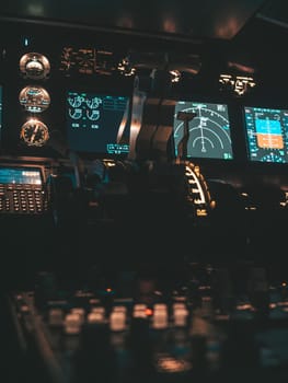 Cockpit view of an airplane during a night-time flight with illuminated instrument panels