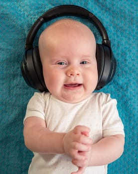 Little boy on blue blanket background with headphones