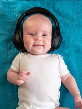 Little boy on blue blanket background with headphones