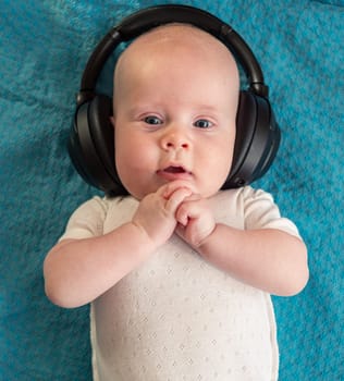 Little boy on blue blanket background with headphones