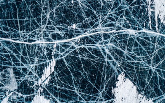 Aerial top down view on the blue cracked ice of the lake Baikal. Winter landscape, frozen lake. Ice kingdom.