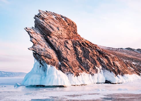 Ogoy island on winter Baikal lake. Winter scenery of Dragon Tail Rock on Ogoy island during sunrise at Lake Baikal.