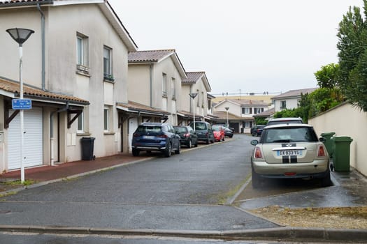 Bordeaux, France - April 26, 2023: A row of houses with various cars parked in front of them on a residential street.