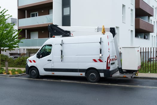 Bordeaux, France - April 26, 2023: A white van is parked on the side of a road, blending in with the surroundings. The vehicle is stationary with no one inside.