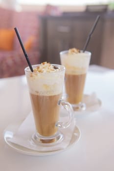 coffee is served in a tall glass glass with a straw. The concept of coffee drinks from the bar menu.