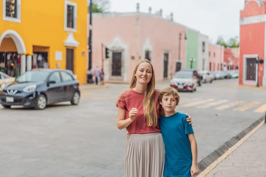 Mother and son tourists explore the vibrant streets of Valladolid, Mexico, immersing herself in the rich culture and colorful architecture of this charming colonial town.