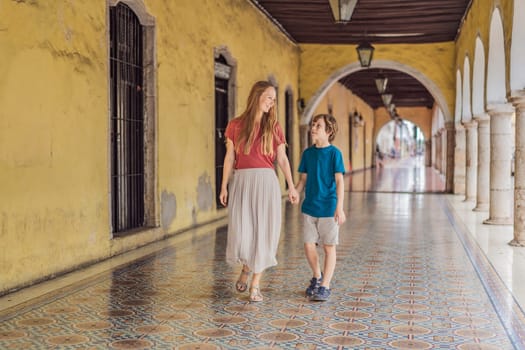 Mother and son tourists explore the vibrant streets of Valladolid, Mexico, immersing herself in the rich culture and colorful architecture of this charming colonial town.