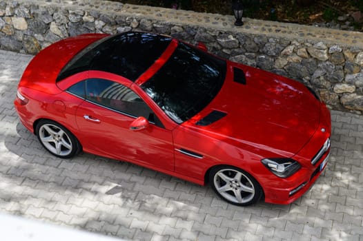 Gaziveren Cyprus 04.18.2024-red Mercedes Benz in the parking lot near the house