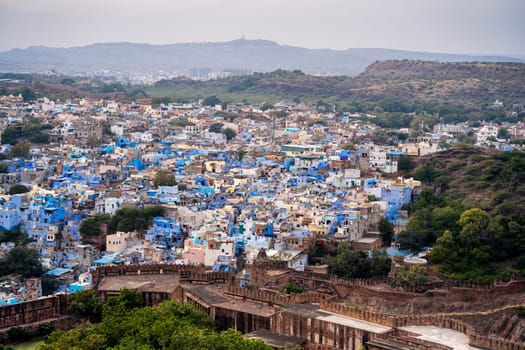 aerial drone shot showing jodhpur blue city cityscape showing traditional houses in middle of aravalli with colorful densely packed houses India