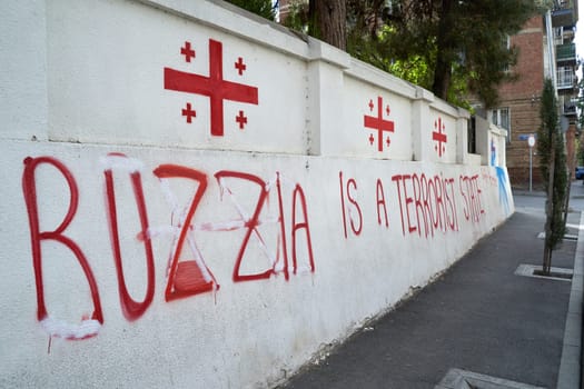 Tbilisi, Georgia - April 17, 2024: Anti-Russian writings and flags of Georgia on the wall