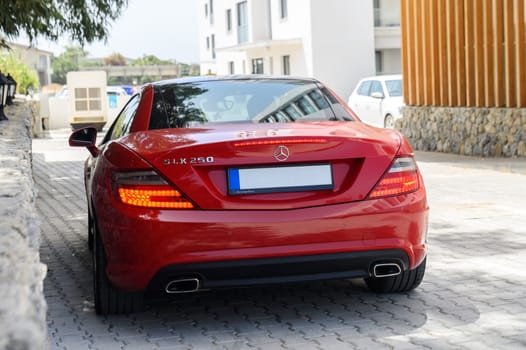 Gaziveren Cyprus 04.18.2024-red Mercedes Benz SLK 250 in the parking lot near the house 2