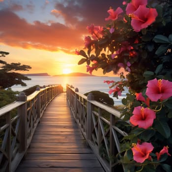Sunset over the sea, all around orange and pink flowers, green leaves, a wooden platform in the middle. Flowering flowers, a symbol of spring, new life. A joyful time of nature waking up to life.