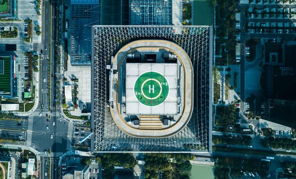 Aerial top view of helipad on the roof of a skyscraper iin downtown with cityscape view on sunny day