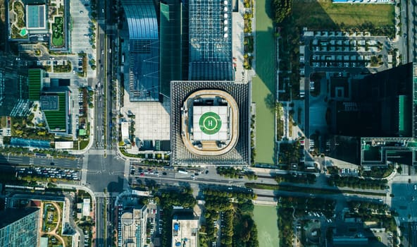 Aerial top view of helipad on the roof of a skyscraper iin downtown with cityscape view on sunny day