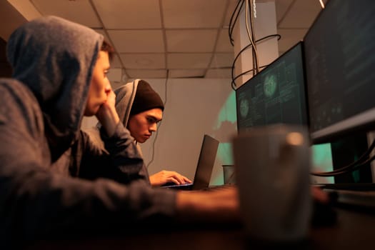 Diverse hackers breaking into professional database, stealing information and cracking passwords. Thieves using spyware and malicious theft to steal sensitive data. Cybercrime, hacking system.