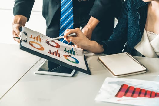 Businessman and businesswoman in meeting working with many financial statement document on desk. Concept of busy business profit analysis and brainstorm. Close up shot at people hands and papers. uds