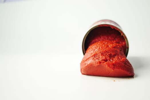 Tomato paste in a preserved container on white background .