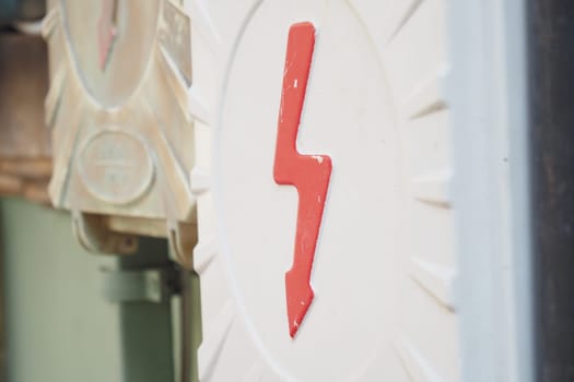 Two electrical boxes with lightning bolt on brick wall.