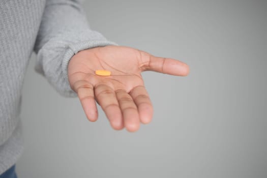 Close up of man hand holding pills with copy space .