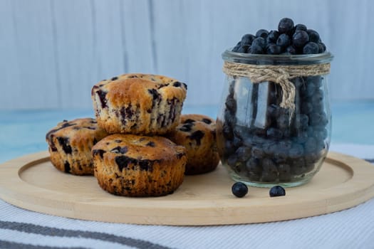 Homemade baked blueberry muffins with fresh harvested blackberries in glass jar. Tasty pastry sweet cupcake dessert. Berry pie Healthy vegan cupcakes with organic berries. Gluten free healthcare recipe from alternative flour