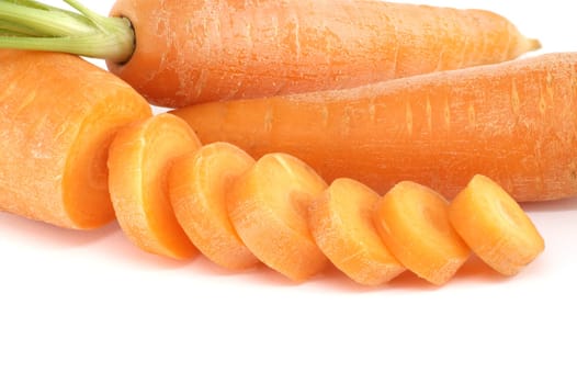 Whole carrot and sliced pieces, all with a bright orange color prepped for cooking or for use in a dish like a salad or stir-fry isolated on a white background