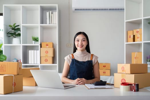 Woman asian in an online store check the customer address and package information on the laptop. Online shopping concept.