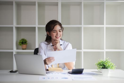 Business woman using calculator for do math finance on wooden desk in office and business working background, tax, accounting, statistics and analytic research concept..