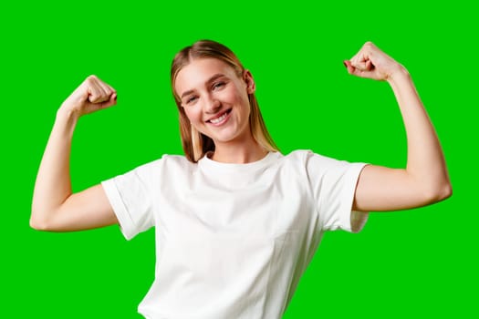 Happy Young Woman Raising Fists against green background in studio
