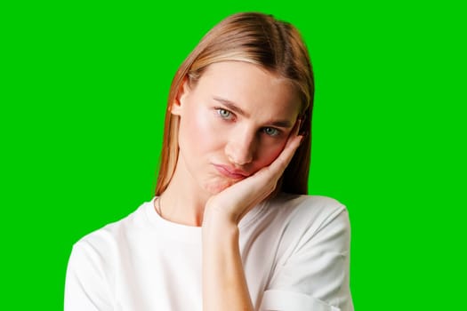 Young Woman With Pursed Lips Expressing Skepticism Against Green Screen Background in studio