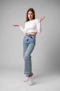 Young Woman in Blue Top Holding Out Hands in studio