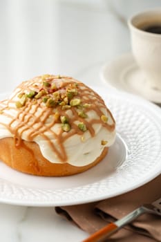 Cinnamon roll bun with icing on plate close up