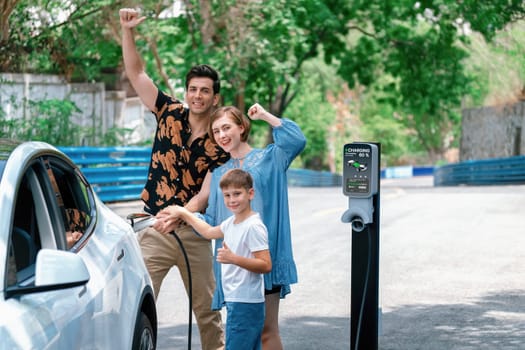 Family road trip vacation with electric vehicle, lovely family recharge EV car with green and clean energy. Natural and eco friendly car travel for sustainable environment. Perpetual