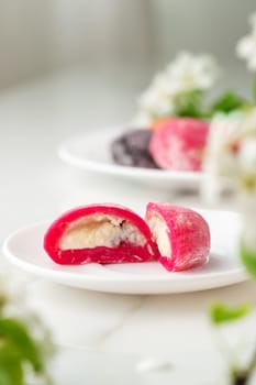 Multi-colored Japanese cakes Mochi in a white plate close up