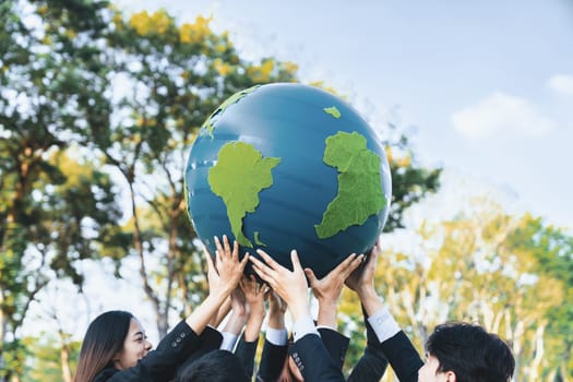 Earth day concept with big Earth globe held by group of asian business people team promoting environmental awareness to solve global warming with environmentally sustainability and ESG principle. Gyre