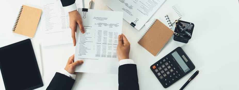 Corporate accountant team use calculator to calculate and maximize tax refunds and improve financial performance based on financial data report. Modern business accounting in panorama top view. Shrewd