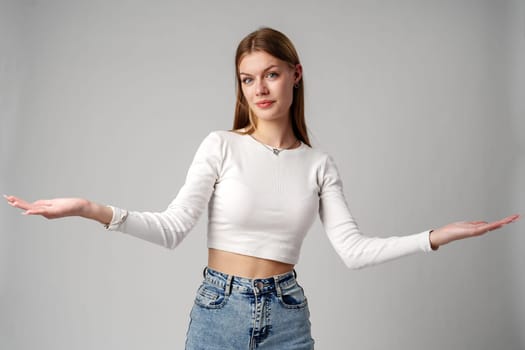 Young Woman in Blue Top Holding Out Hands in studio