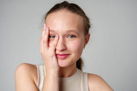 Young Woman Covering Face With Hand on gray background close up