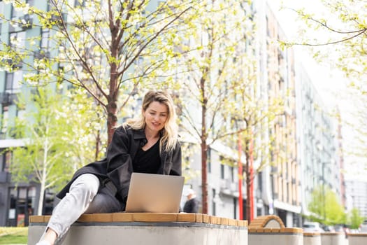 Young business woman working at laptop in the city. High quality photo