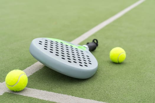 Paddle racket, next to the ball and on a carpet of the play area. High quality photo
