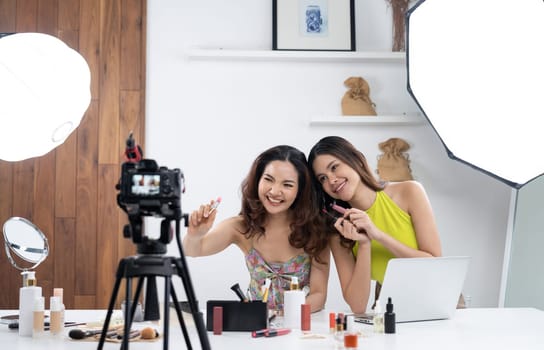 Woman influencer shoot live streaming vlog video review makeup uttermost social media or blog. Happy young girl with cosmetics studio lighting for marketing recording session broadcasting online.