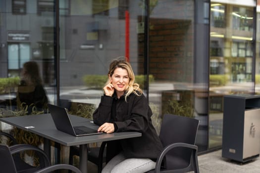 Young woman with laptop outside. High quality photo