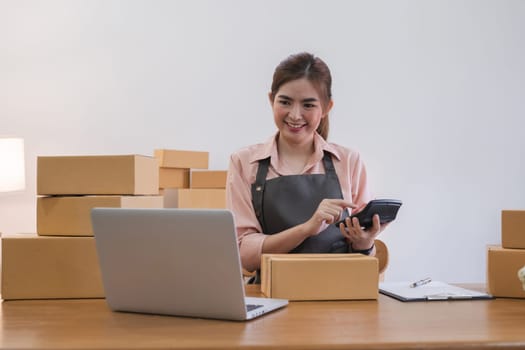 Business From Home Asian woman preparing package delivery box Shipping for shopping online. young start up small business owner at home online order.