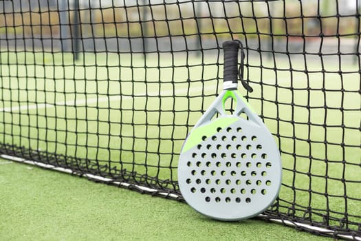 Paddle racket, next to the ball and on a carpet of the play area. High quality photo